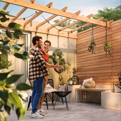 A couple standing proudly at their backyard