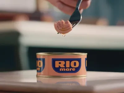A can of Rio Mare tuna is opened, a single piece of tuna is taken out of it with a fork